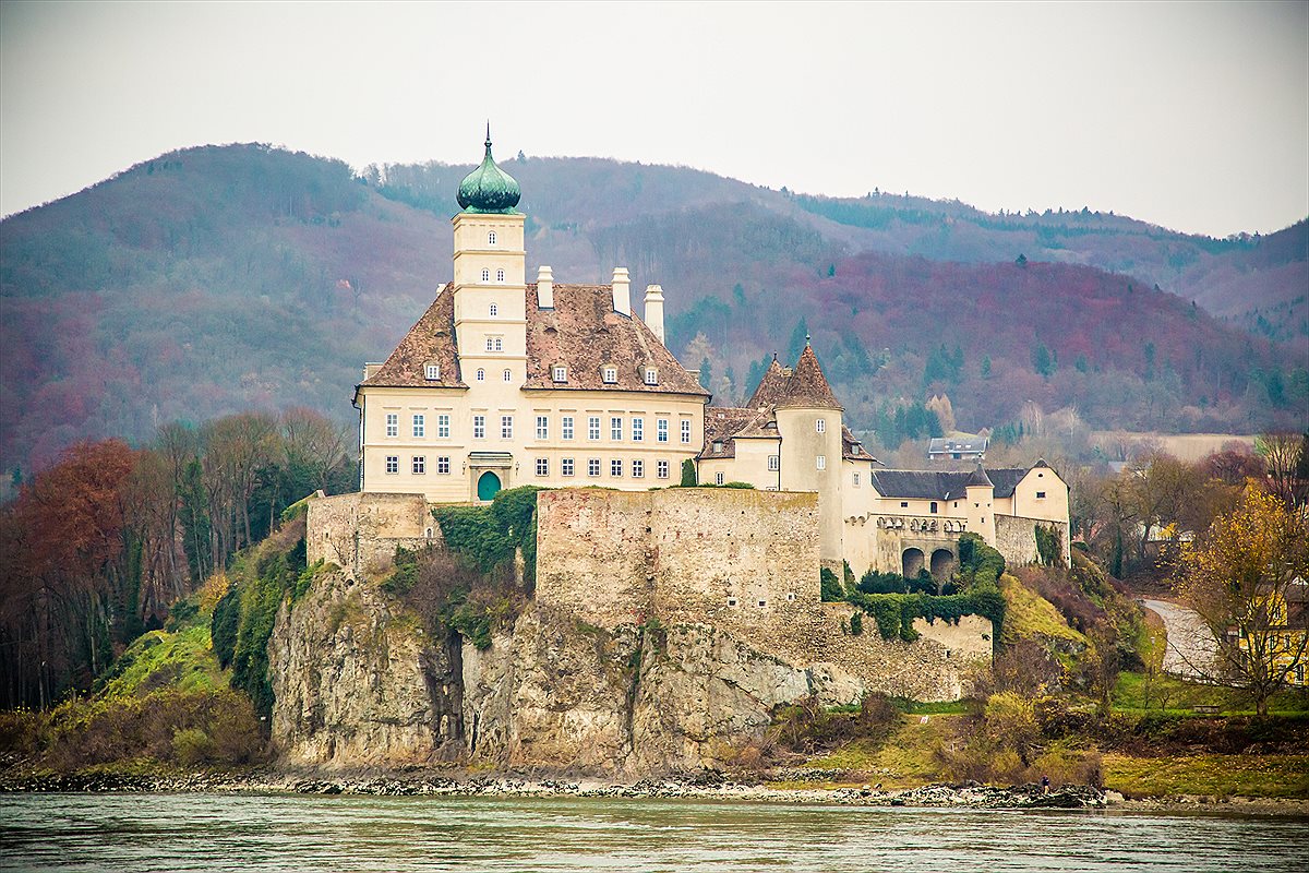 AmaWaterways group river cruise gliding past a European riverside village
